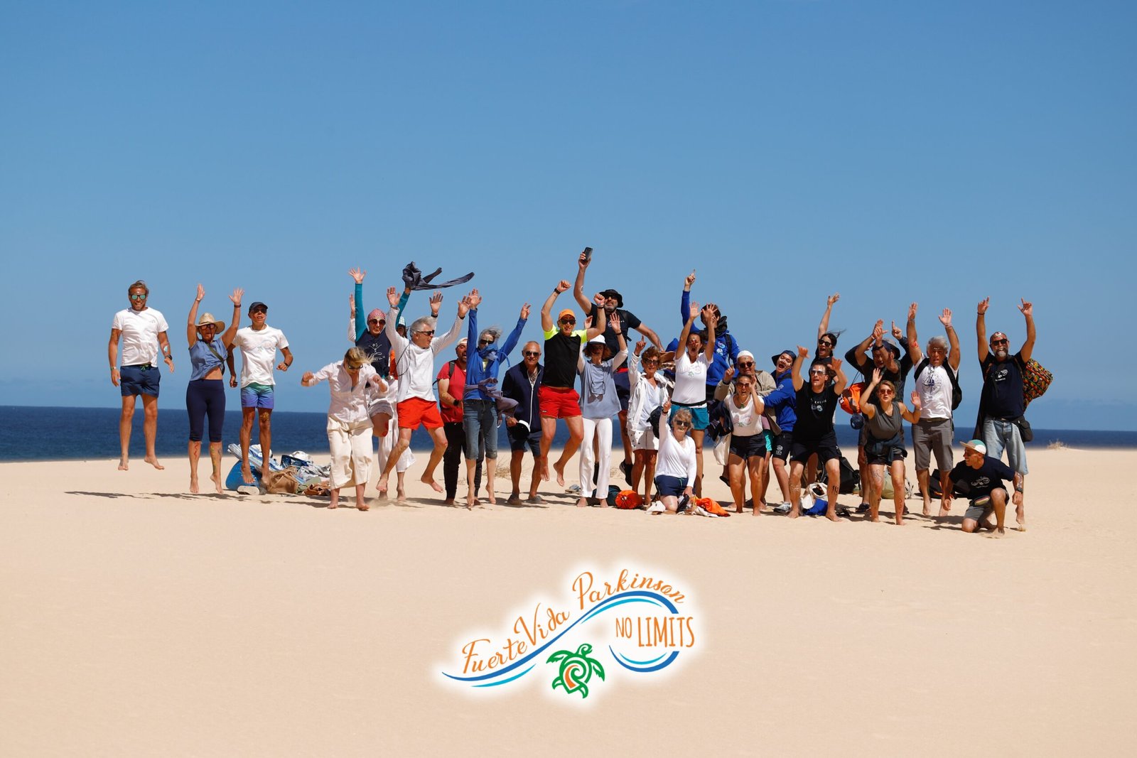 gruppo di persone con parkinson che saltano di felicità sulle dune di corralejo